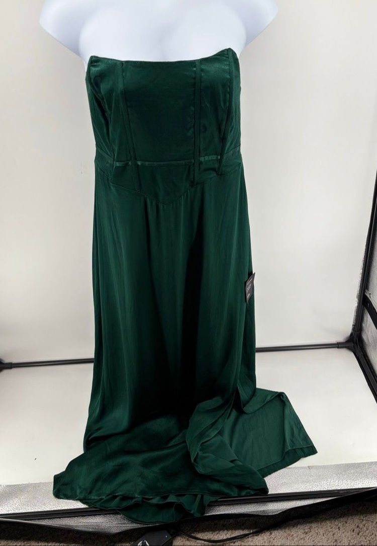 Deep-green strapless gown with vertical bodice seams, a defined waist, and a softly draped skirt.