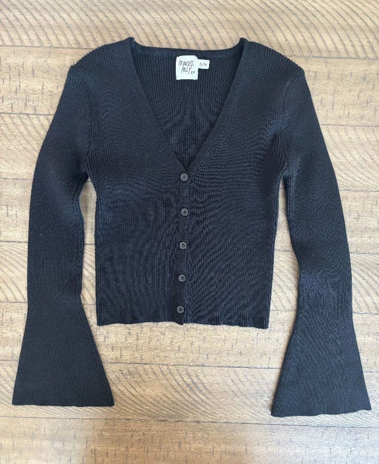 Black ribbed button-front cardigan laid flat, showing its cropped shape and hem.