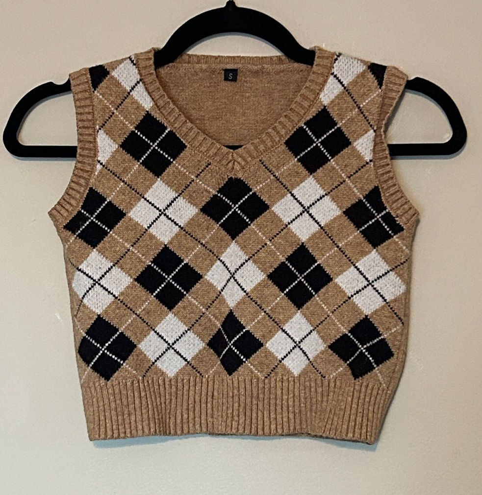 Camel, black, and white argyle V-neck sweater vest on a hanger.