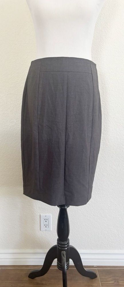 Charcoal pencil skirt on a dress form, with a defined waistband and vertical waist-to-hip shaping seams.