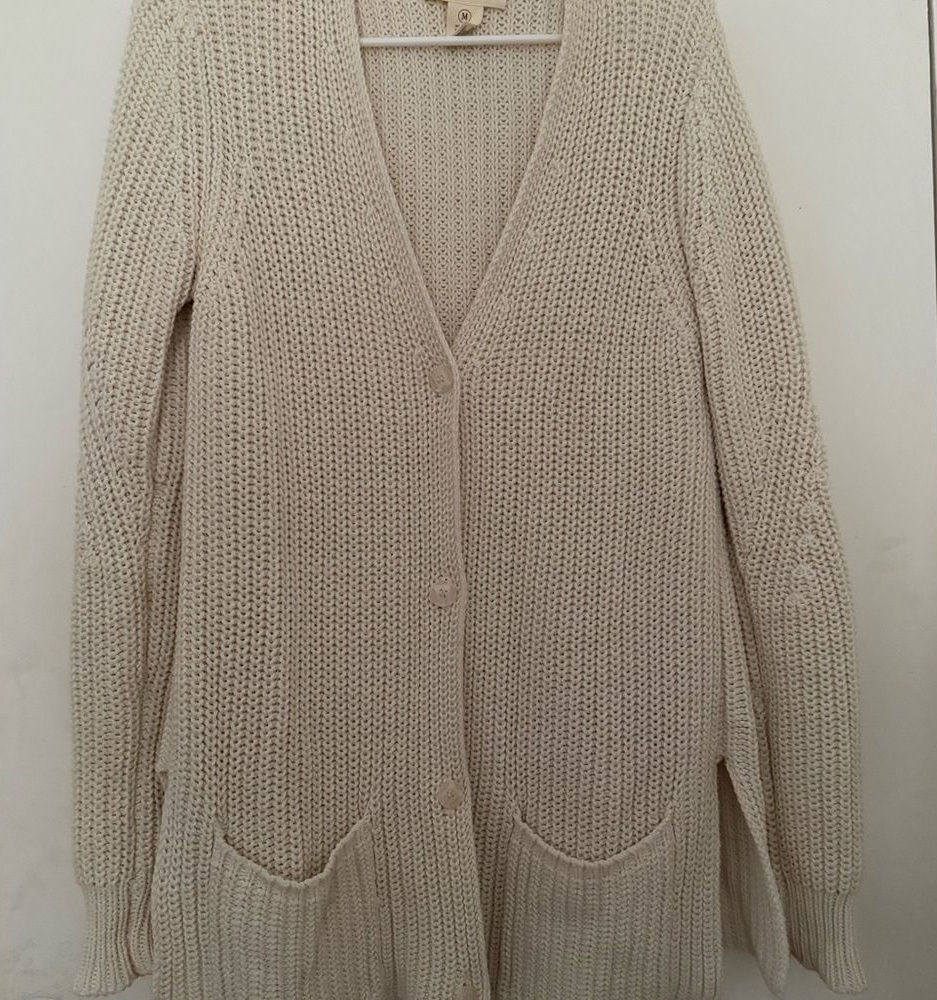 Oatmeal button-front knit cardigan with deep pockets, laid flat on a light background.
