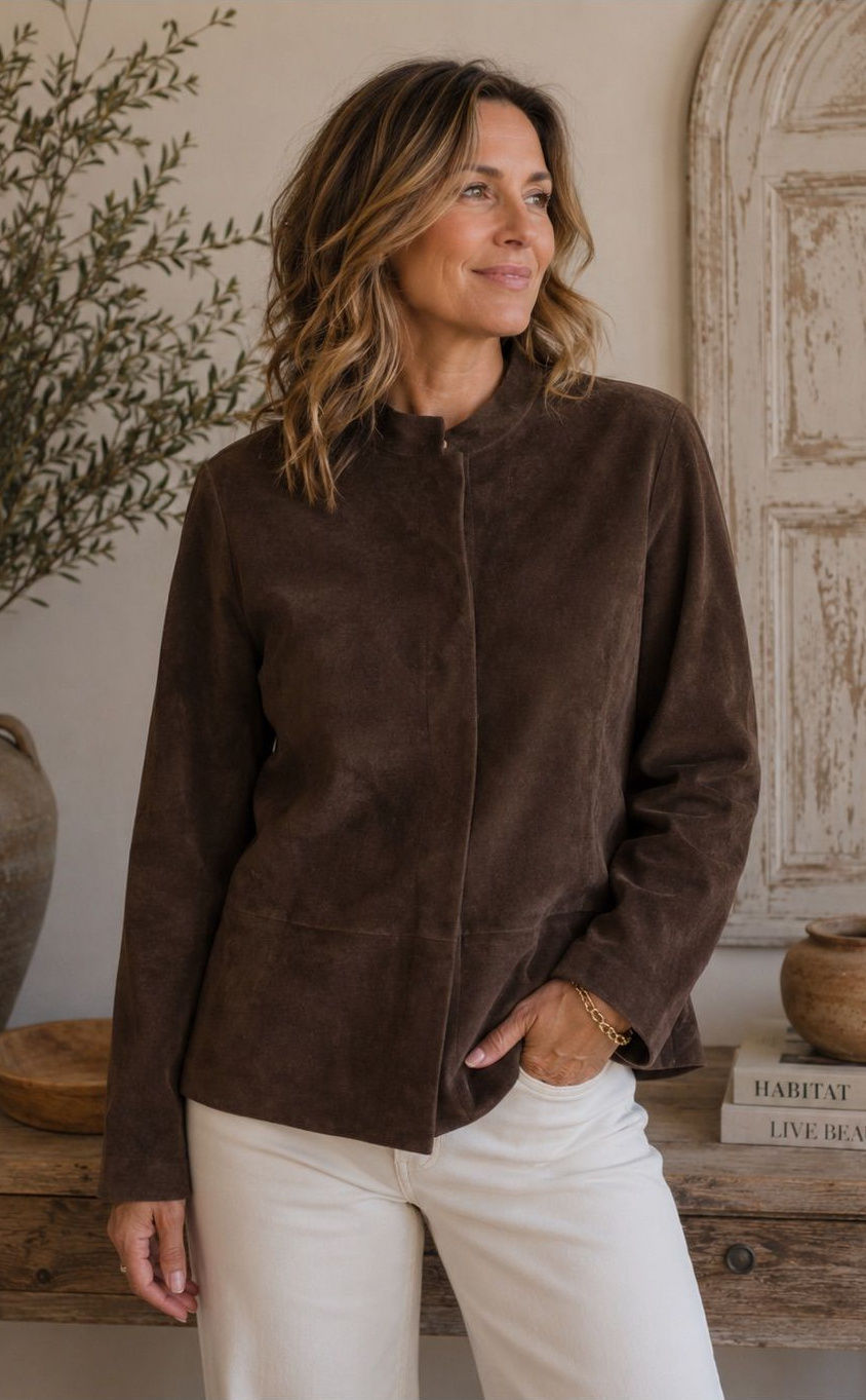 Person wearing a dark chocolate-brown faux-suede jacket with clean lines and a relaxed fit.