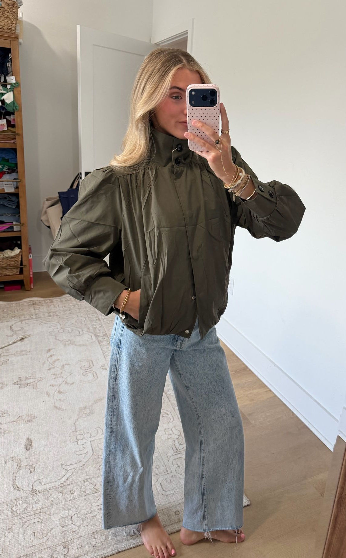 Olive lightweight bomber jacket worn with its tall funnel collar raised, showing the neckline and shoulders.