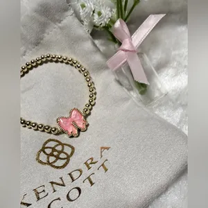 Kendra Scott Haley Bow Gold Stretch Bracelet featuring a custom-carved pink bow thumbnail 3