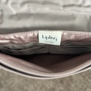 Kipling crossbody purse. Adjustable strap. Flap over closure w/ snap. Light pink thumbnail 7