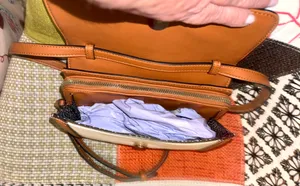 White and brown crossbody bag with adjustable strap. The design features a front flap with a brown leather detail and a clip closure. thumbnail 4