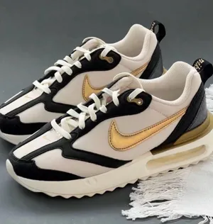 Nike Women's White Black Sneakers with Metallic Gold Swoosh thumbnail 1