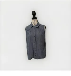 The Cabi Chambray Sleeveless Blouse in blue is a stylish and versatile top perfect for summer, fall, or spring. With a collared neckline, button closure, and ruffle accents, this high-low shirt features a cutout back for added interest. thumbnail 2