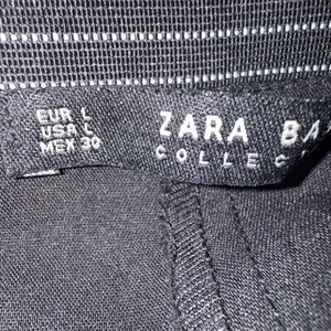 ZARA BASIC Collection Black trousers zip hem Back stripe straight leg size Lg The ZARA BASIC Collection Black trousers are stylish dress pants in size L with a zip hem feature and back stripe accents. Made from a fabric blend of blended polyester, these pants have a straight leg style and pockets for added convenience. Perfect for casual occasions in the summer, fall, and spring, these trousers are machine washable for easy care. The black pants with stripes offer a city-inspired theme, making them a versatile and chic addition to any woman's wardrobe. thumbnail 6