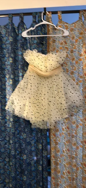 strapless tulle mini dress featuring a cream or light beige mesh fabric adorned with classic black polka dots. It is designed with a heavily ruched, pleated sweetheart bodice, a defined cinched waistband, and a voluminous tiered ruffled skirt. thumbnail 4