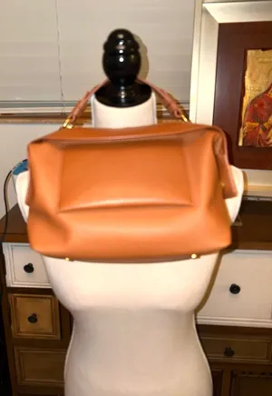The Free Assembly brown bag features a faux leather structure with top handles and a removable crossbody strap. thumbnail 1