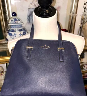 This bag is a Kate Spade Cedar Street Maise satchel in navy blue with gold-tone hardware, made of Saffiano leather, with a top zip closure and top handles. thumbnail 2