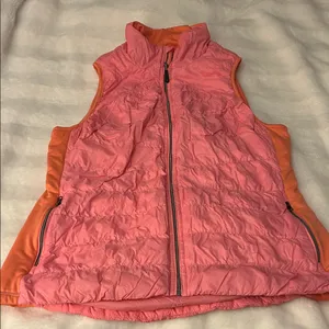 a Tangerine women's puffer vest in pink with orange side panels. Size large thumbnail 1