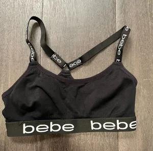 Sleek black bralette featuring bold bebe logo on elastic band. Stretch fabric for light support and comfort. Thin adjustable logo straps with a stylish crisscross back. Clean, minimalist look ideal for layering. Bebe size small thumbnail 1