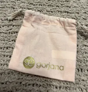 Blush pink velvet drawstring pouch. Gold foil Gorjana logo on front. Soft fabric and secure closure. Perfect for small jewelry or gifts. thumbnail 1