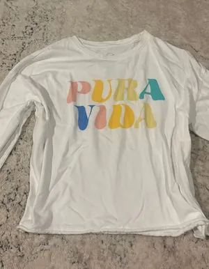 Pura Vida white long sleeve shirt with rainbow-colored 'PURA VIDA' text thumbnail 1