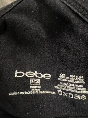 Sleek black bralette featuring bold bebe logo on elastic band. Stretch fabric for light support and comfort. Thin adjustable logo straps with a stylish crisscross back. Clean, minimalist look ideal for layering. Bebe size small thumbnail 4