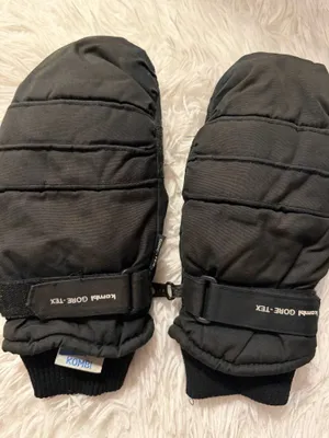 Kombi Unisex Black GORE-TEX Winter Mittens / Gloves - Description: Stay warm with these high-performance Kombi GORE-TEX winter mittens. Featuring a classic black unisex design, these mittens include adjustable wrist straps for a secure fit and cozy ribbed cuffs to seal out the cold, as shown They also feature a convenient pairing clip to ensure they never get separated. As seen the palms are equipped with a durable, textured grip that provides excellent traction for winter sports or daily wear. Perfect for skiing, snowboarding, or shoveling snow. In great condition and ready for the slopes! thumbnail 1