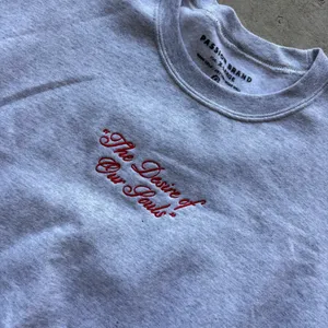 Passion Brand crewneck sweatshirt features a distinct red embroidered cursive script reading "The Desire of Our Souls" across the chest thumbnail 2