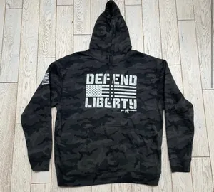 Howitzer "Defend Liberty" Black Camo Hoodie Elevate your casual wear with this rugged and patriotic Howitzer "Defend Liberty" Hoodie. Featuring a stealthy black multicam (camo) pattern, this hoodie is designed for those who value both style and a strong message of freedom. Constructed with high-quality, durable fabric, it offers a comfortable fit perfect for outdoor adventures, range days, or daily wear. Product Features: • Brand: Howitzer Manufacturing Co. • Design: Bold "DEFEND LIBERTY" distressed graphic with the American flag and an AR-15 silhouette on the front. • Back Detail: A vertical "DEFEND LIBERTY" spine graphic for a unique look from every angle. • Sleeve Detail: Features the Howitzer brand American flag patch on the sleeve. • Pattern: Modern black/dark grey camouflage. • Style: Pullover with adjustable drawstring hood and a spacious kangaroo front pocket. thumbnail 2