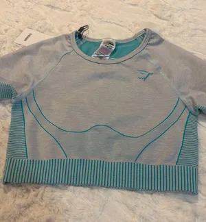 Gymshark Women's Teal and Gray Long Sleeve Crop Top Size Small . Stylish long sleeve crop top by Gymshark. Features a sleek teal and gray design. Perfect for workouts.. NWT thumbnail 11