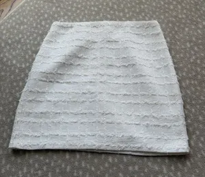 Chic white mini skirt with textured horizontal detailing. Slim, flattering silhouette. Easy to pair with tops or jackets for polished looks. thumbnail 1