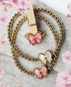 Kendra Scott Haley Bow Gold Stretch Bracelet featuring a custom-carved pink bow thumbnail 1