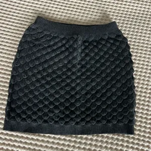 Black textured knit mini skirt with repeating scale-like pattern #mini #knit thumbnail 1