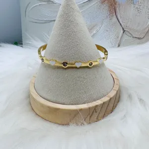 This chic bracelet showcases a beautiful gold finish with delicate white heart d thumbnail 2