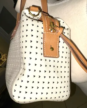 The Fossil Emma Satchel bag in white and gray with a polka dot print and brown leather handles stands out for its classic key charm. thumbnail 4