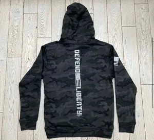 Howitzer "Defend Liberty" Black Camo Hoodie Elevate your casual wear with this rugged and patriotic Howitzer "Defend Liberty" Hoodie. Featuring a stealthy black multicam (camo) pattern, this hoodie is designed for those who value both style and a strong message of freedom. Constructed with high-quality, durable fabric, it offers a comfortable fit perfect for outdoor adventures, range days, or daily wear. Product Features: • Brand: Howitzer Manufacturing Co. • Design: Bold "DEFEND LIBERTY" distressed graphic with the American flag and an AR-15 silhouette on the front. • Back Detail: A vertical "DEFEND LIBERTY" spine graphic for a unique look from every angle. • Sleeve Detail: Features the Howitzer brand American flag patch on the sleeve. • Pattern: Modern black/dark grey camouflage. • Style: Pullover with adjustable drawstring hood and a spacious kangaroo front pocket. thumbnail 7