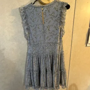 This is a light blue floral mini dress by She+Sky featuring a deep V-neckline and a tiered ruffled hem. thumbnail 2