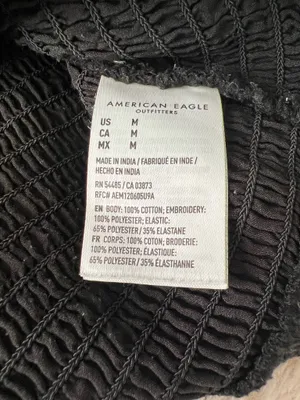 Black smocked crop top featuring dramatic puff sleeves with textured embroidery. Square neckline and fitted bodice create a flattering silhouette. Easy to style for casual or dressed-up looks. American Eagle size medium thumbnail 3