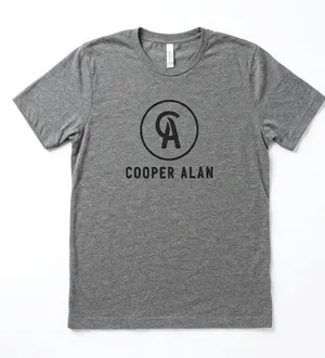 Cooper Alan Graphic Tee Heather Gray Women's Size Large Add this fan-favorite Cooper Alan graphic t-shirt to your collection! This official merchandise features the iconic "CA" logo in a circular crest on the chest, printed on a premium Bella + Canvas heather gray tee. Crafted for comfort, it has a classic crew neck and short sleeves, making it perfect for concerts or everyday wear. • Size: Large • Condition: Excellent pre-owned condition—worn but shows no flaws and is in perfect shape. • Brand: Bella + Canvas (Cooper Alan Merch) • Material: Soft, breathable cotton-poly blend. thumbnail 1