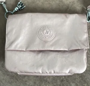 Kipling crossbody purse. Adjustable strap. Flap over closure w/ snap. Light pink thumbnail 2