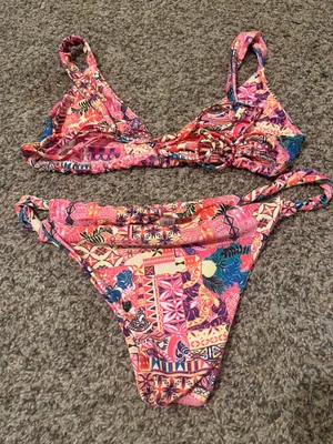 &merci Vibrant floral bikini set perfect for summer. Features a mix of red, pink, and blue hues for a standout look at the beach or pool. thumbnail 6