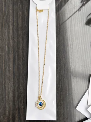 This gold-plated necklace features a celestial-themed pendant with a blue gem representing a planet surrounded by a crescent moon. thumbnail 2