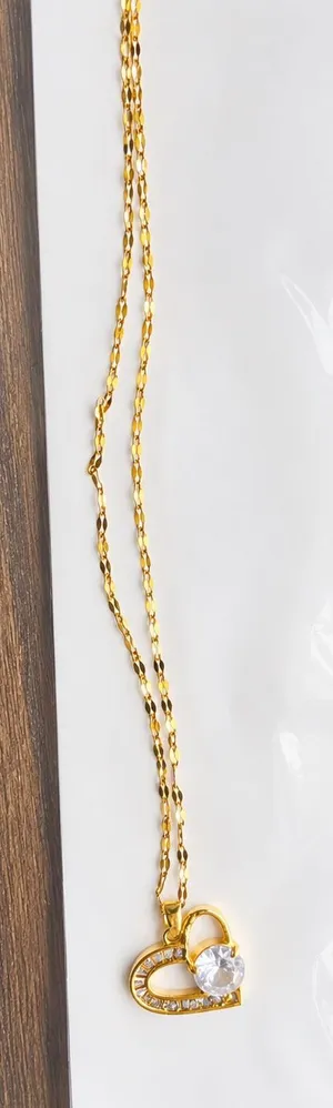 This elegant heart necklace is made from 18k gold-plated stainless steel and features a large central cubic zirconia stone surrounded by smaller crystal accents. thumbnail 1