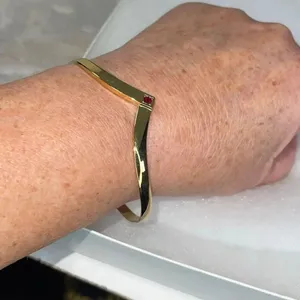 Avon gold tone V shaped cuff bracelet with faux ruby or garnet. Large thumbnail 7