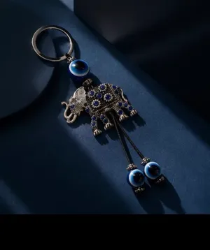 Cute elephant keychain with evil eye beads. It's made of metal with blue gem accents. Attaches to a standard key ring. thumbnail 3