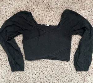 Black smocked crop top featuring dramatic puff sleeves with textured embroidery. Square neckline and fitted bodice create a flattering silhouette. Easy to style for casual or dressed-up looks. American Eagle size medium thumbnail 1