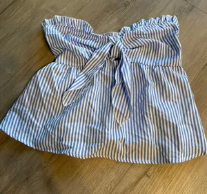 SHEIN Women’s Size Small Blue Striped Tie-Front Strapless Peplum Top – Like New Excellent Condition Description Adorable blue and white vertical stripe strapless tube top featuring a sweet front-tie bow detail and a flattering peplum hemline! Features: Smocked elastic back for a secure, comfortable fit and a flirty sweet-heart bust profile. Style: Perfect for summer outings, beach trips, or pairing with your favorite denim jeans! Condition: Like new, excellent pre-owned condition with no flaws. Brand: SHEIN Size: Women's Small thumbnail 1