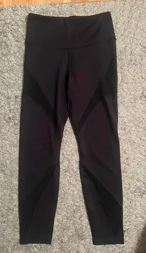 Black stretchy Yvette leggings with mesh design on outer thighs and ankles #activewear No flaws The lighting makes it look a little brown but they are plain black leggings I am a 26 in waist and 5'6" for reference thumbnail 1