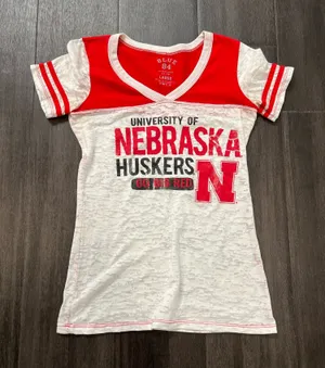 Blue 84 women’s short-sleeve tee. Bold "Nebraska Huskers" graphics with team N logo. Red yoke and sleeve accents with white body. Lightweight and fan-ready for game day. Size large thumbnail 1
