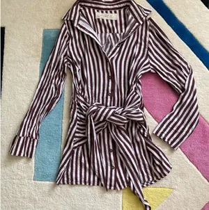 Jen’s Pirate Booty Amaya brown and white striped mini dress in size XS. This has only been worn once and has no rips, tears, or stains. Some color transfer between stripes from washing but it’s not really noticeable as seen in photos. The waist can be tied in front with excess or in back (I like to go around twice and tie in back). Ultra soft and flowy material, love this dress and only selling as it just isn’t quite my style. Measures 30” long, 17” across chest, 14” across at waist, 22” long sleeve (from shoulder seam). thumbnail 2