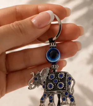 Cute elephant keychain with evil eye beads. It's made of metal with blue gem accents. Attaches to a standard key ring. thumbnail 1