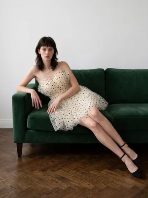 strapless tulle mini dress featuring a cream or light beige mesh fabric adorned with classic black polka dots. It is designed with a heavily ruched, pleated sweetheart bodice, a defined cinched waistband, and a voluminous tiered ruffled skirt. thumbnail 3