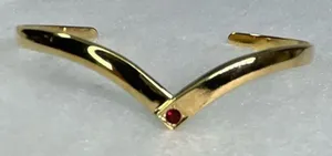 Avon gold tone V shaped cuff bracelet with faux ruby or garnet. Large thumbnail 1