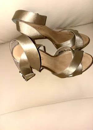 Arezzo brand sandals stand out for their sophisticated gold tone and crisscrossing straps. Elegant style with a high heel. Adjustable ankle strap. Metallic gold color. thumbnail 3