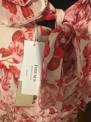 New with tags Ever New Astrid Ruffle Tiered Mini dress in size 4. This garment has a red peony blossom floral print on a light background. It is designed with a button-front bodice, ruffled cap sleeves, and a tiered skirt. The back features a large open cutout with tie closures at the neck and waist. thumbnail 3